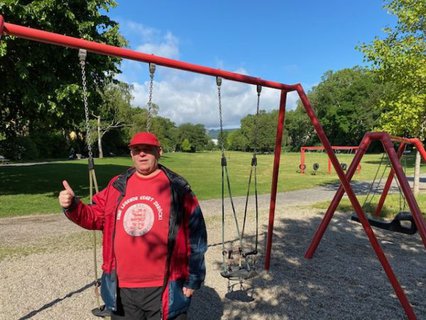 Ottmar Miles-Paul im Kassler Goethepark vor der Schaukel mit Blick über den Park und dem Herkules in der Ferne